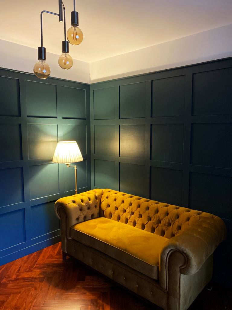 Musztardowa sofa dwuosobowa Chesterfield Grand w pokoju w stylu retro